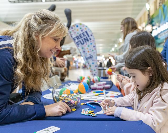 A MAC Ambassador interacts with a young passenger at MSP Airport